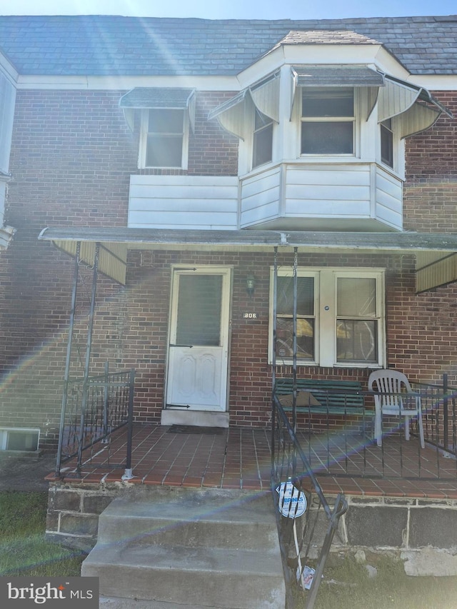 view of front facade with covered porch and brick siding