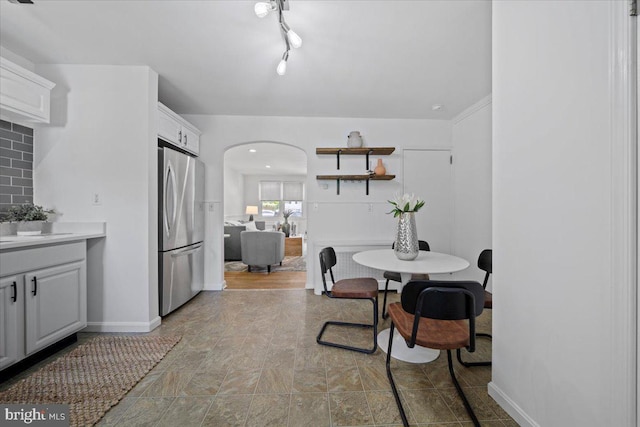 dining area with arched walkways and baseboards