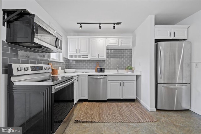 kitchen featuring a sink, white cabinetry, decorative backsplash, light countertops, and appliances with stainless steel finishes