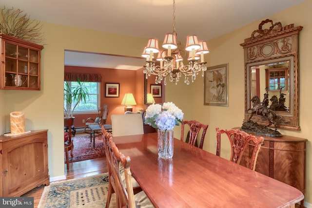 dining space featuring wood finished floors and a chandelier