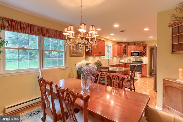 dining room featuring baseboard heating, light wood finished floors, a chandelier, and recessed lighting