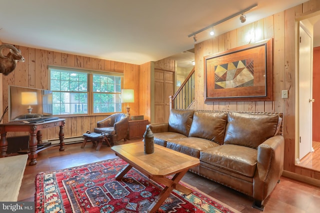 living room with rail lighting, wooden walls, and stairway