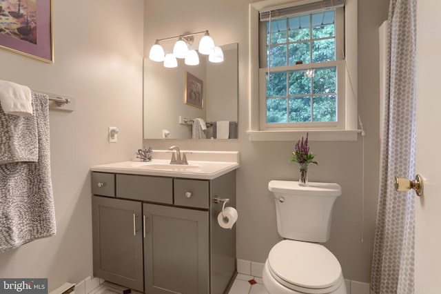 bathroom with toilet, vanity, and baseboards