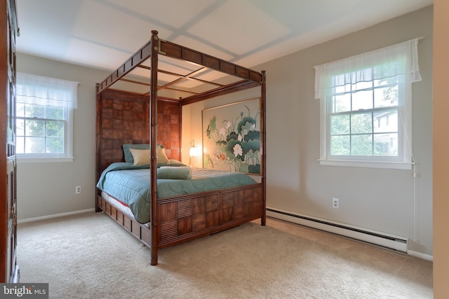carpeted bedroom with baseboard heating and baseboards