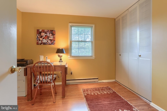 office space with a baseboard radiator, wood finished floors, and baseboards
