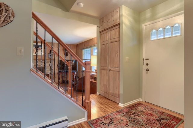 entryway with light wood finished floors, stairs, and baseboard heating