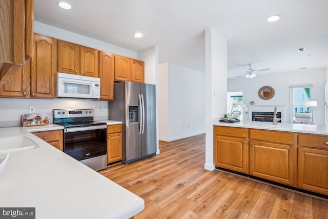 701 Ballast Way, Annapolis, MD 21401 - kitchen with appliances with stainless steel finishes, light countertops, ceiling fan, light wood-type flooring, and brown cabinets
