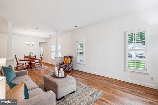 701 Ballast Way, Annapolis, MD 21401 - living room with ornate columns, light wood finished floors, a chandelier, and baseboards