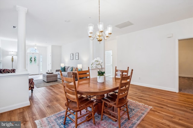 701 Ballast Way, Annapolis, MD 21401 - dining space with light wood finished floors, a chandelier, and decorative columns