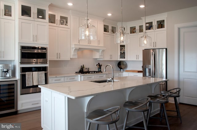 kitchen with a sink, wine cooler, dark wood-type flooring, white cabinets, and appliances with stainless steel finishes