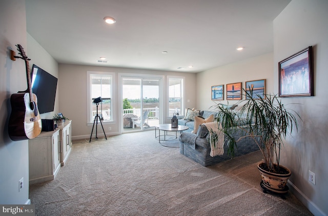 carpeted living area featuring baseboards and recessed lighting