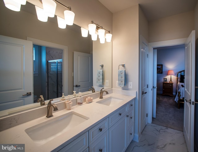 ensuite bathroom featuring a stall shower, marble finish floor, double vanity, and a sink