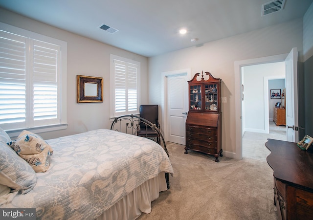 bedroom with light colored carpet, baseboards, and visible vents
