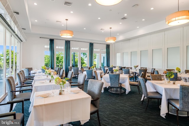 dining room featuring visible vents, a towering ceiling, a healthy amount of sunlight, and recessed lighting