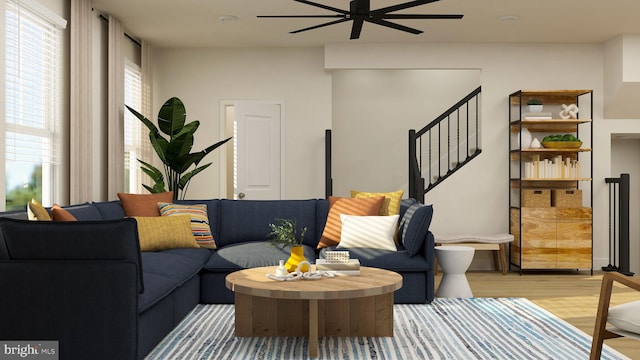 living room with ceiling fan, stairs, and light wood-style floors