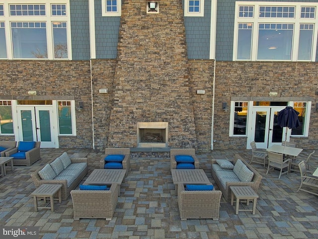 view of patio featuring french doors and an outdoor living space with a fireplace