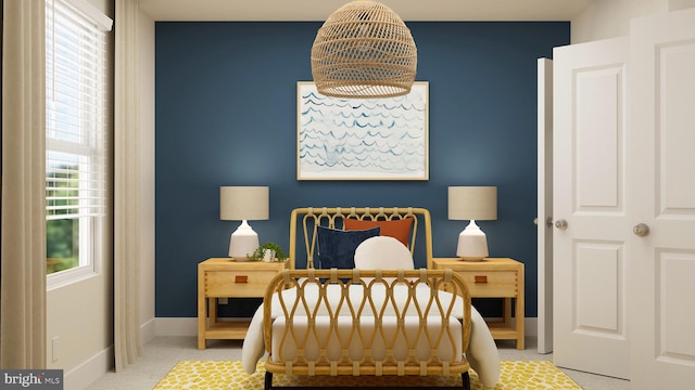carpeted bedroom featuring an inviting chandelier and baseboards