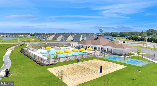 community pool with a water play area, fence, a residential view, a water slide, and volleyball court