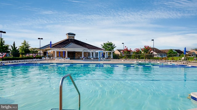 community pool with a patio area and fence