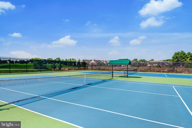 view of tennis court featuring fence and community basketball court