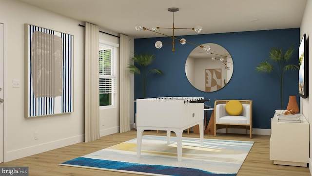 living area featuring baseboards, a notable chandelier, and wood finished floors