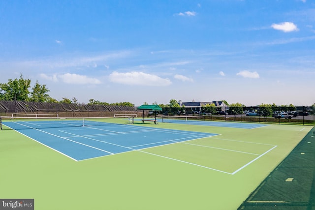 view of tennis court featuring fence and community basketball court