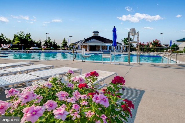 pool with a patio area and fence