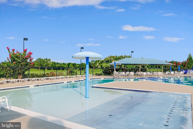 community pool with fence and a patio