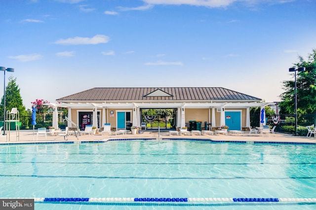 community pool with fence and a patio