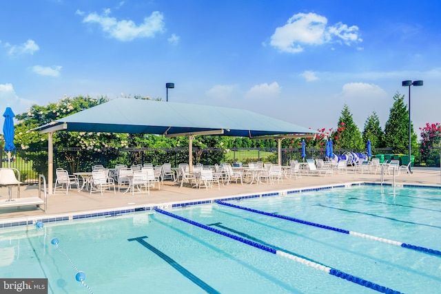 pool with a patio area and fence
