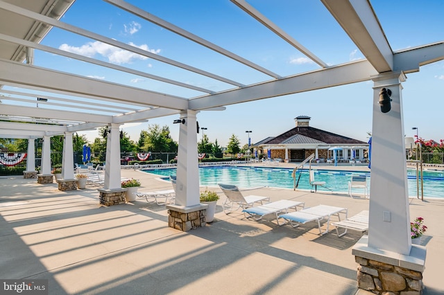 community pool with a patio area, a pergola, and fence