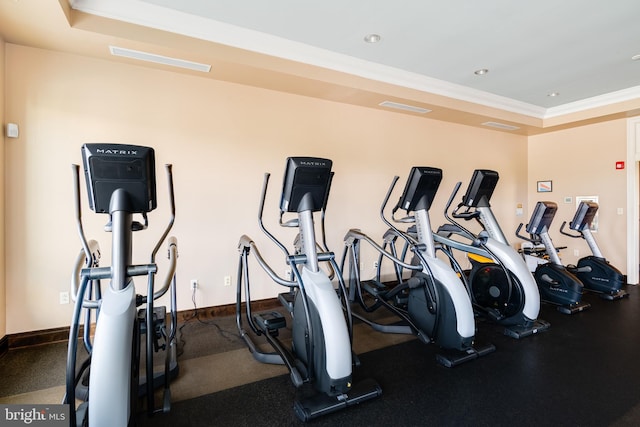 exercise room with crown molding, baseboards, a raised ceiling, and recessed lighting