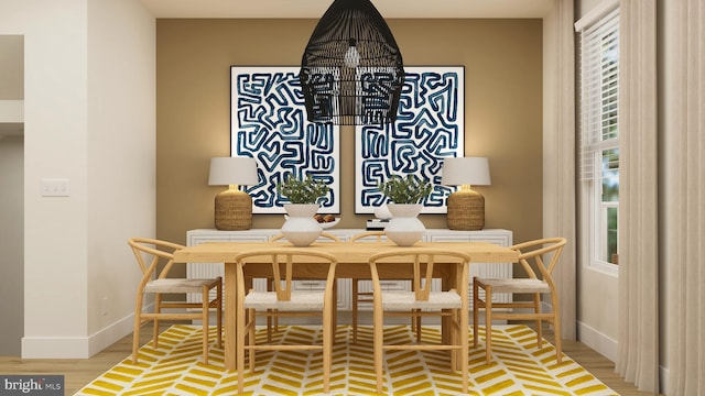 dining space featuring baseboards and wood finished floors