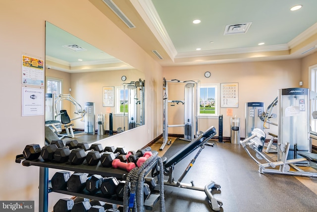 exercise room with a raised ceiling, ornamental molding, and recessed lighting