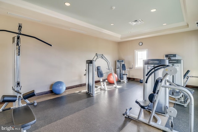 workout room with ornamental molding, visible vents, recessed lighting, a tray ceiling, and baseboards