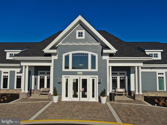 exterior space with roof with shingles and french doors