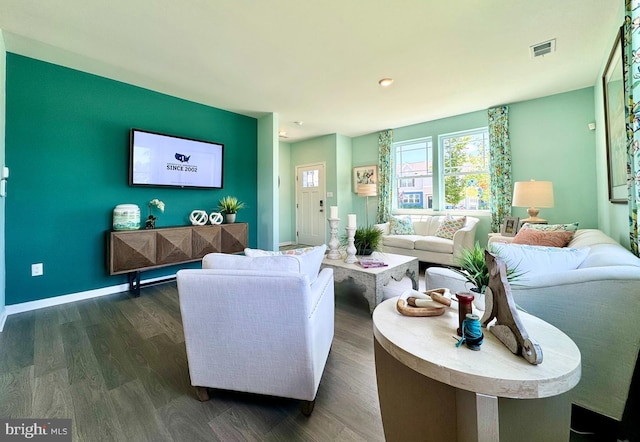 living room featuring baseboards, dark wood finished floors, and visible vents