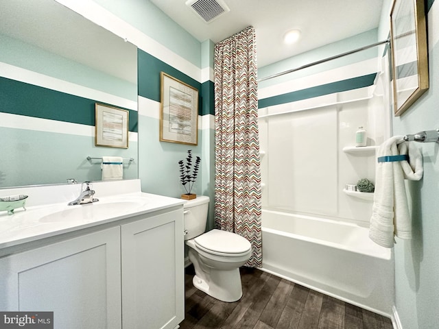 full bath featuring toilet, wood finished floors, vanity, visible vents, and shower / tub combo