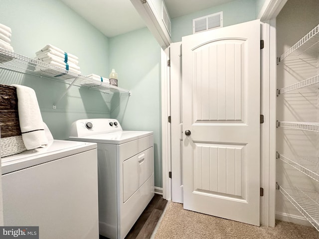 washroom featuring washing machine and dryer, laundry area, and visible vents