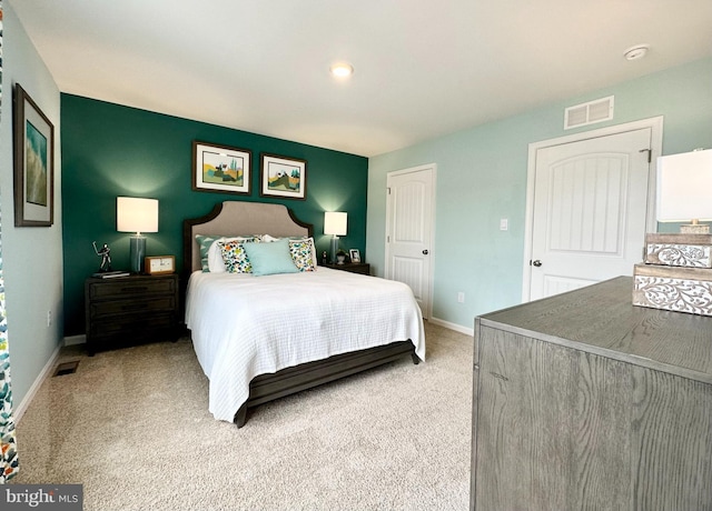 bedroom with baseboards, light carpet, and visible vents