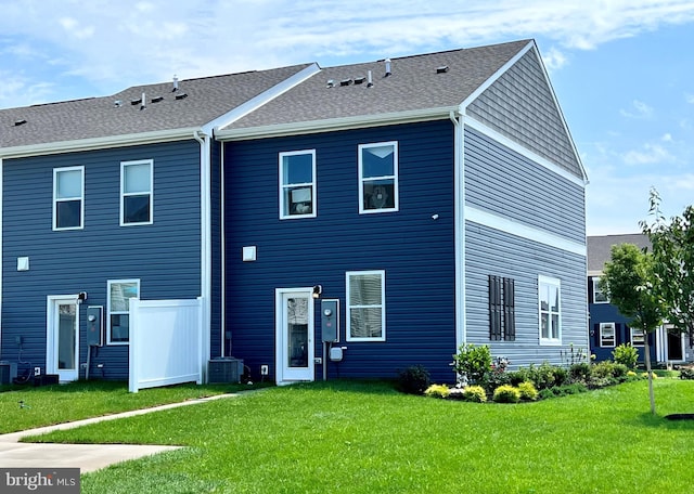 back of property featuring central AC unit and a yard