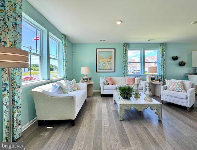 living area featuring visible vents, wood finished floors, and baseboards