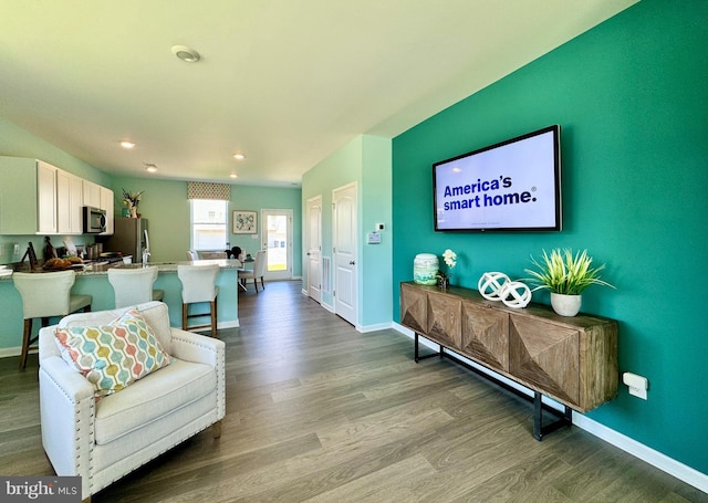 living area featuring dark wood finished floors, baseboards, and recessed lighting