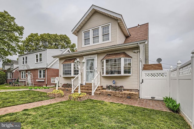 view of front of house featuring a front yard, fence, and entry steps