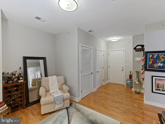 living area with light wood finished floors, baseboards, and visible vents