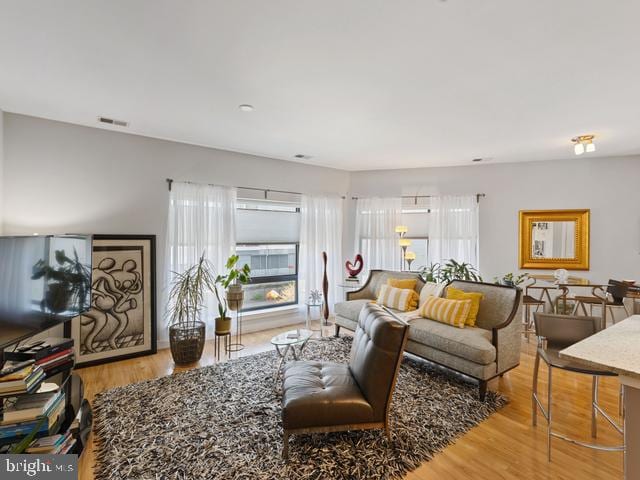 living room featuring visible vents and wood finished floors