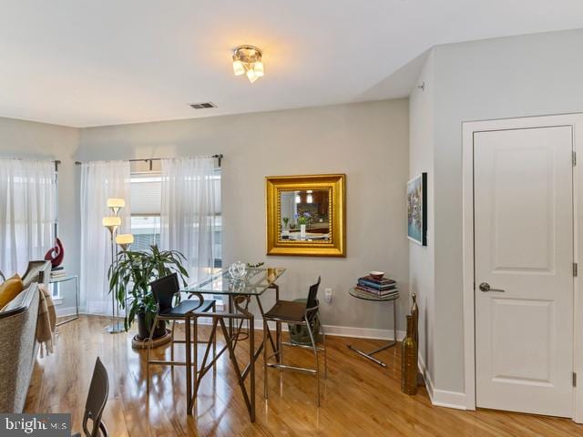 dining room featuring baseboards, visible vents, and wood finished floors