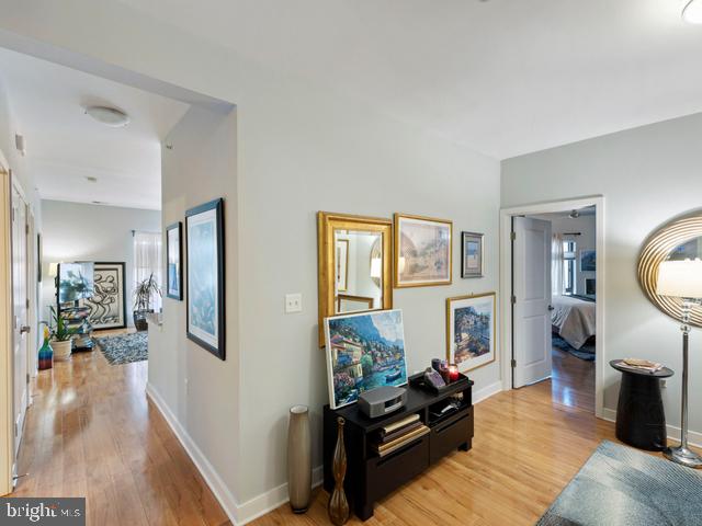 corridor featuring light wood-style flooring and baseboards