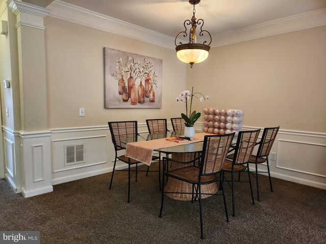 carpeted dining area featuring crown molding, wainscoting, and a decorative wall