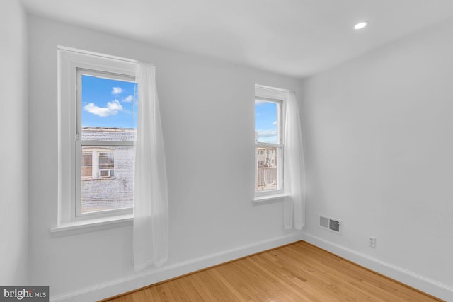 unfurnished room with baseboards, light wood finished floors, and recessed lighting